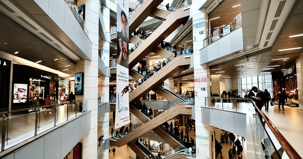 View of a shopping mall featuring diverse retail brands, representing the variety of businesses powered by the Shopify platform.