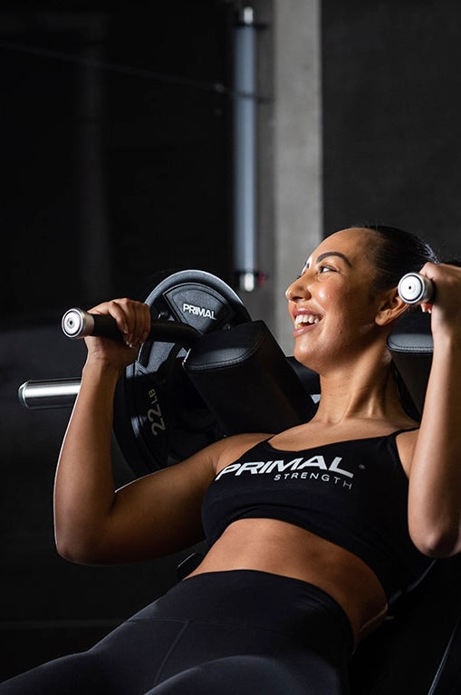 Woman using Primal Strength gym equipment